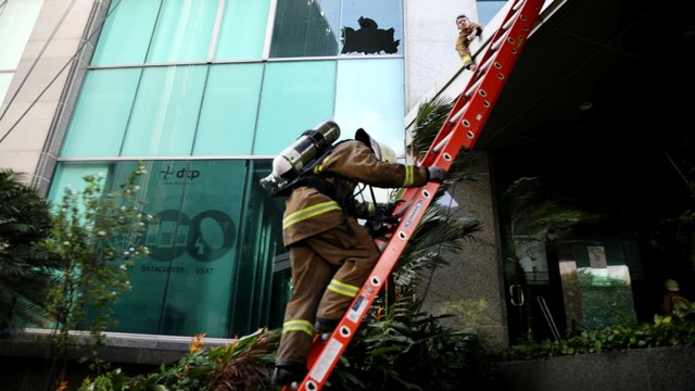 Petugas pemadam kebakaran mengevakuasi korban di lokasi kebaran di gedung Cyber, Kuningan, Jakarta Selatan, Kamis (2/12/2021). Foto: Aditia Noviansyah/kumparan
