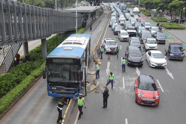 Petugas berupaya mengevakuasi bus TransJakarta yang menabrak separator di Jalan Jenderal Sudirman, Jakarta. Foto: ANTARA FOTO/Reno Esnir