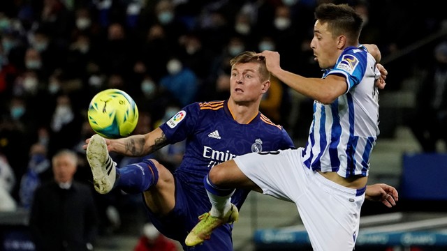 Pemain Real Madrid Toni Kroos beraksi dengan pemain Real Sociedad Andoni Gorosabel di Reale Arena, San Sebastian, Spanyol, Sabtu (4/12). Foto: Vincent West/REUTERS
