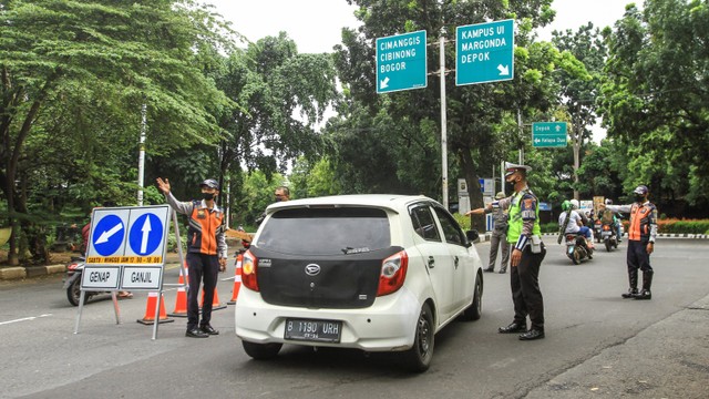 Sejumlah petugas memeriksa kendaraan roda empat saat uji coba ganjil - genap di Jalan Margonda Raya, Depok, Jawa Barat, Minggu (5/12).  Foto: Asprilla Dwi Adha/ANTARA FOTO