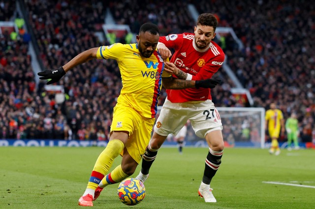 Pemain Crystal Palace Jordan Ayew beraksi dengan pemain Manchester United Alex Telles di Old Trafford, Manchester, Inggris, Minggu (5/12). Foto: Phil Noble/REUTERS