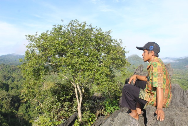 Warga Desa Berkun, menikmati panorama yang terlihat dari atas Bukit Tamulun. (Foto: M Sobar Alfahri/Jambikita)