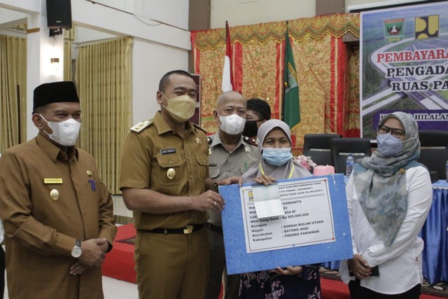 Wakil Gubernur Sumatera Barat Audy Joinaldy menyerahkan uang ganti untung lahan tol Padang-Pekanbaru seksi I untuk 16 bidang tanah kepada penerima. Foto: dok Humas