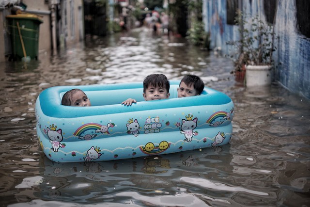 Sejumlah anak bermain saat banjir rob menggenangi pemukiman warga Jalan Lodan Dalam, Ancol, Pademangan, Jakarta Utara, Selasa (7/12). Foto: Jamal Ramadhan/kumparan
