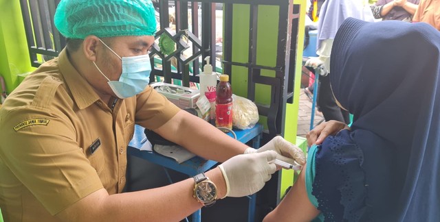 Matlilla saat melakukan vaksinasi terhadap warga di RW 15 RT 4 Bulak Jaya, Kelurahan Wonokusumo, Kecamatan Semampir, Rabu (8/12). Foto: Dok.Puskesmas Wonokusumo