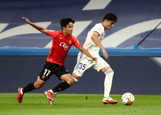 Pemain RCD Mallorca Takefusa Kubo duel dengan pemain Real Madrid Miguel Gutierrez saat bertanding di Santiago Bernabeu, Madrid, Spanyol. Foto: Sergio Perez/Reuters