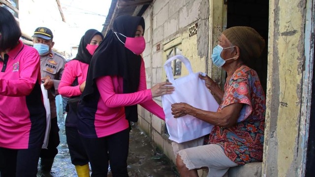 Ketua Bhayangkari Cabang Pelabuhan Tanjung Priok Ujik Putu Kholis membagikan bantuan makanan untuk warga terdampak banjir rob di Muara Angke, Jakarta Utara, Rabu (8/12). Foto: Dok. Istimewa