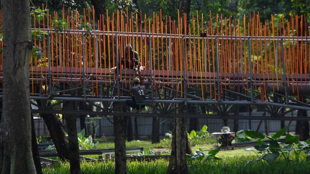 Pekerja menyelesaikan pembuatan jembatan penghubung taman selatan dan utara pada revitalisasi taman tebet menjadi Tebet Eco Garden di Jakarta, Kamis (9/12/2021). Foto: Hafidz Mubarak A/ANTARA FOTO