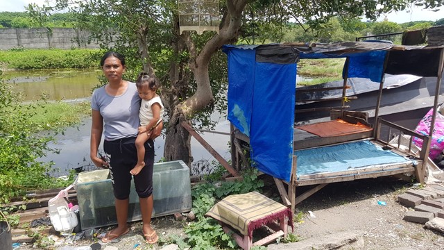 Susiloningsih dan putri bungsunya, warga Tempurejo Tanggul Surabaya di depan pohon yang menurut suaminya pernah ada penampakan genderuwo. Foto-foto: Windy Goestiana/Basra