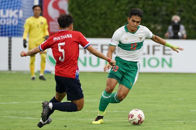 Pemain Timnas Indonesia Rachmat Irianto duel dengan pemain Timnas Laos Phathana Phommathep pada pertandingan grup B Piala AFF 2020 di Stadion Bishan, Singapura, Minggu (12/12/21). Foto: Humas PSSI/Antara Foto