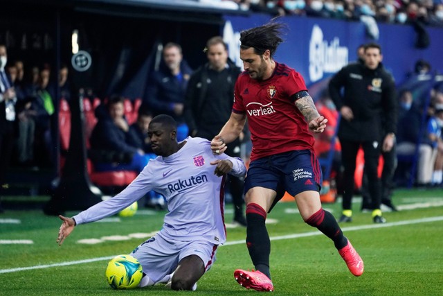 Pemain Barcelona Ousmane Dembele berebut bola dengan pemain Osasuna pada pertandingan lanjutan Liga Spanyol di El Sadar Stadium, Pamplona, Spanyol Foto: Vincent West/REUTERS