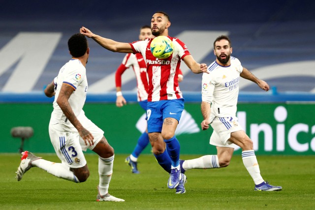 Pemain Real Madrid Dani Carvajal berusaha menghadang pemain Atletico Madrid Matheus Cunha pada pertandingan lanjutan Liga Spanyol di Santiago Bernabeu, Madrid, Spanyol.  Foto: Sergio Perez/REUTERS