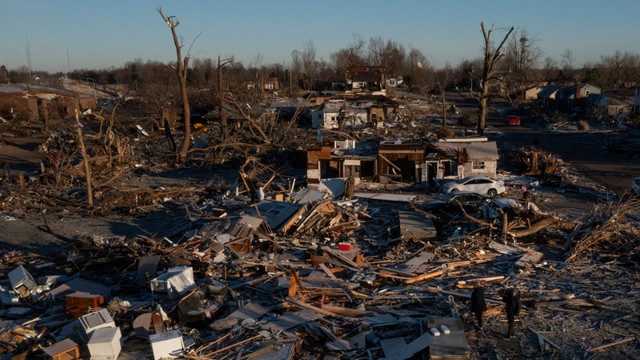 Warga berdiri di puing-puing tempat tinggalnya yang hancur akibat angin tornado. Foto: REUTERS/Adrees Latif