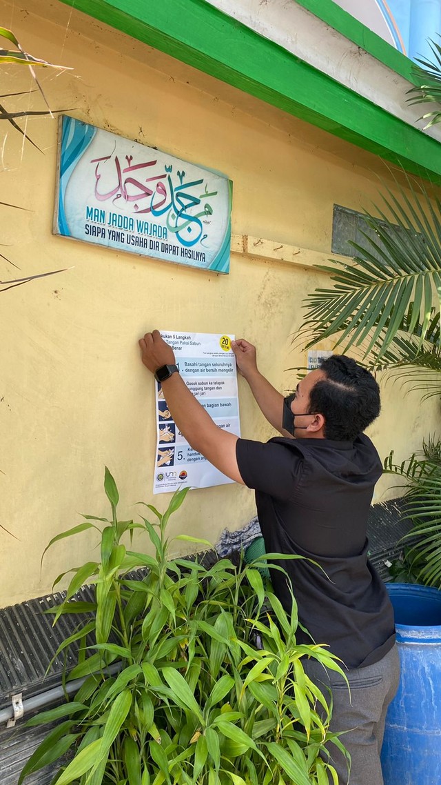 Pemasangan poster pencegahan COVID-19 di lingkungan Desa Bocek.