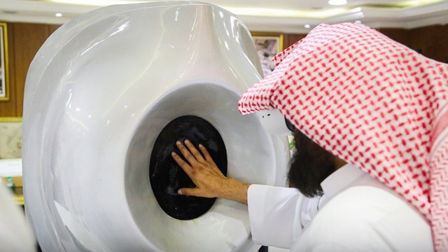 Syeikh Abdurrahman As-Sudais meraba Hajar Aswad tiruan sembari memakai alat VR, Senin (13/12). Foto: gph.gov.sa