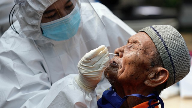 Petugas kesehatan yang mengenakan alat pelindung diri (APD) mengambil sampel swab untuk tes penyakit virus corona (COVID-19) di Jakarta. Foto: REUTERS/Ajeng Dinar Ulfiana