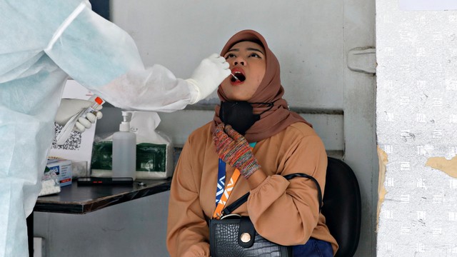 Petugas kesehatan yang mengenakan alat pelindung diri (APD) mengambil sampel swab untuk tes penyakit virus corona (COVID-19) di Jakarta. Foto: REUTERS/Ajeng Dinar Ulfiana