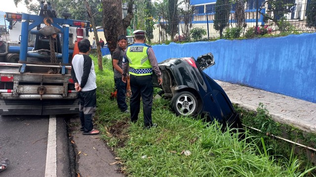 Satu unit mobil Honda City terjun ke parit sedalam empat meter di Jalan Raya Cipanas, Kampung Panyaweuyan, Desa Ciherang, Kecamatan Pacet, Kabupaten Cianjur, Jawa Barat, Jumat (17/12). Foto: Dok. Istimewa