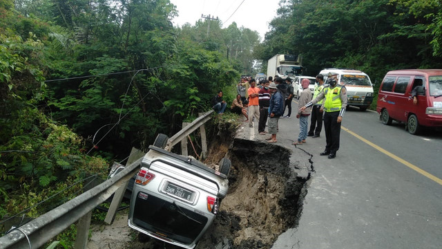 Mobil Toyota Kijang di Toba terperosok jalan lintas Sumatera yang longsor. Foto: Dok. Istimewa