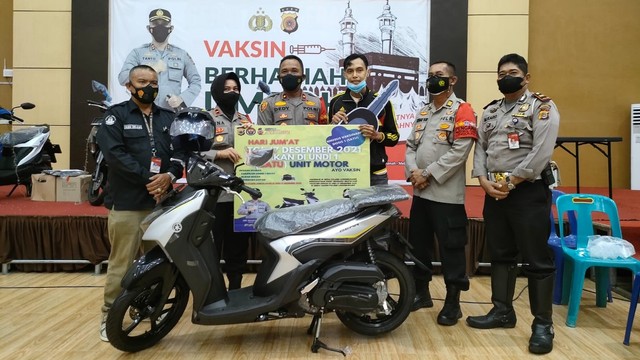Nanda Saputra (ketiga kanan) warga Uteunkot, Kecamatan Muara Dua, Kota Lhokseumawe, Aceh, mendapat sepeda motor usai menjalani vaksinasi COVID-19. Foto: Dok. Polres Lhokseumawe