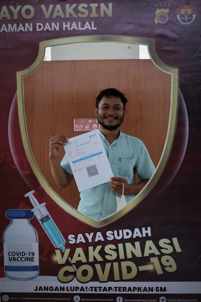 Warga menunjukkan sertifikat vaksinasi COVID-19. Foto: Abdul Hadi/acehkini 