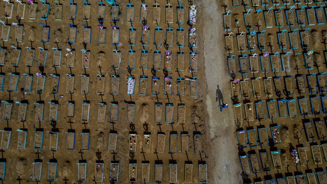Pemandangan udara seorang penggali kubur berjalan di antara kuburan korban COVID-19 di pemakaman Nossa Senhora Aparecida di Manaus, negara bagian Amazonas, Brasil, pada 29 April 2021. Foto: MICHAEL DANTAS/AFP