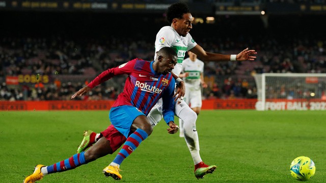 Pemain FC Barcelona Ousmane Dembele beraksi dengan pemain Elche Johan Mojica di Stadion Camp Nou, Barcelona, Spanyol, Sabtu (18/12). Foto: Albert Gea/REUTERS