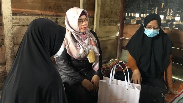Wakil Ketua II DPRK Nagan Raya, Puji Hartini (tengah) bersama pendamping korban (masker biru) saat berkunjung ke rumah keluarga anak korban pemerkosaan, Senin (20/12). Foto: Siti Aisyah/acehkini
