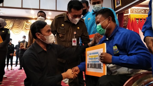 Gubernjur Jambi dan Ketua DPRD Provinsi Jambi menyerahkan bonus secara simbolik pada atlet berprestasi di Peparnas XVI Papua. (Foto: M Sobar Alfahri/Jambikita)