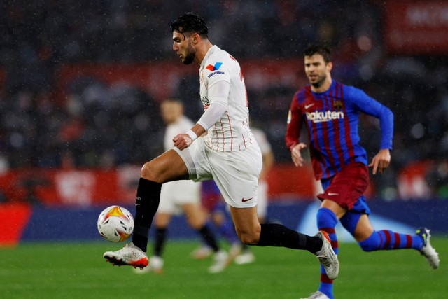 Pemain FC Barcelona Gerard Pique berusaha mengejar pemain Sevilla Rafa Mir pada pertandingan lanjutan Liga Spanyol di stadion Ramon Sanchez Pizjuan, Sevilla, Spanyol. Foto: Marcelo Del Pozo/REUTERS