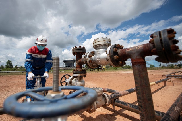 Pekerja PT Pertamina Hulu Rokan (PHR) mengontrol kerangan pipa produksi yang berasal dari sumur menuju stasiun pengumpul minyak mentah, Blok Rokan, Bengkalis, Riau, Rabu (22/12/2021). Foto: Nova Wahyudi/Antara Foto