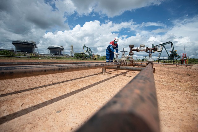 Pekerja PT Pertamina Hulu Rokan (PHR) mengontrol kerangan pipa produksi yang berasal dari sumur menuju stasiun pengumpul minyak mentah, Blok Rokan, Bengkalis, Riau, Rabu (22/12/2021). Foto: Nova Wahyudi/Antara Foto