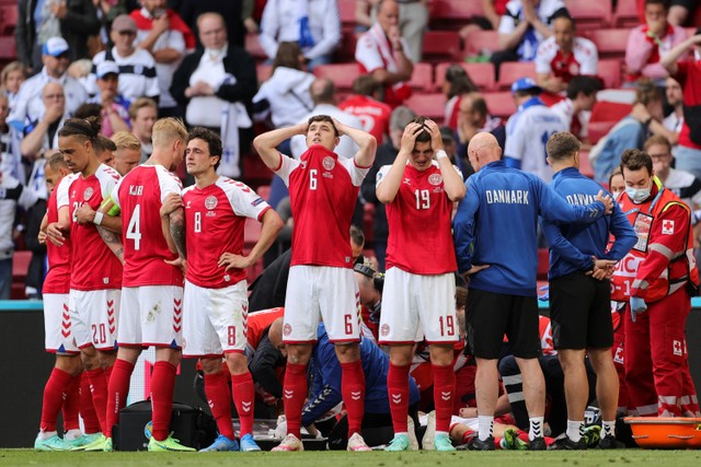 Pemain Denmark saat tim medis merawat gelandang Denmark Christian Eriksen setelah ia pingsan di lapangan saat pertandingan Grup B UEFA EURO 2020 antara Denmark dan Finlandia di Stadion Parken di Kopenhagen pada 12 Juni 2021. Foto: Friedemann Vogel / POOL / AFP