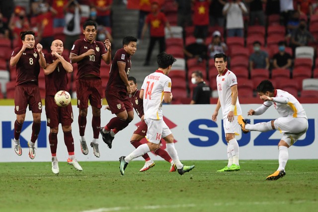 Pemain Vietnam Nguyen Quang Hai menendang bola ke arah gawang Thailand pada pertandingan Semi Final Leg 2 Piala AFF 2020 di National Stadium, Singapura, Minggu (26/12).
Foto: Roslan RAHMAN / AFP