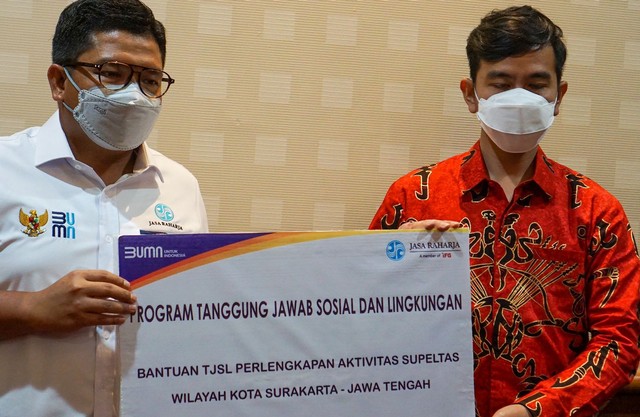 Direktur Hubungan Kelembagaan Jasa Raharja, Munadi Herlambang, menyerahkan bantuan kepada sukarelawan pengatur lalu lintas di Surakarta. Foto: dok. Jasa Raharja