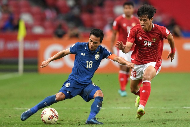 Pemain Thailand Chanathip Songkrasin (kiri) berebut bola dengan pesepakbola Indonesia Alfeandra Dewangga Santosa pada pertandingan leg pertama final AFF Suzuki Cup 2020 antara Indonesia dan Thailand di National Stadium, Singapura, (29/12/2021). Foto: Roslan RAHMAN / AFP