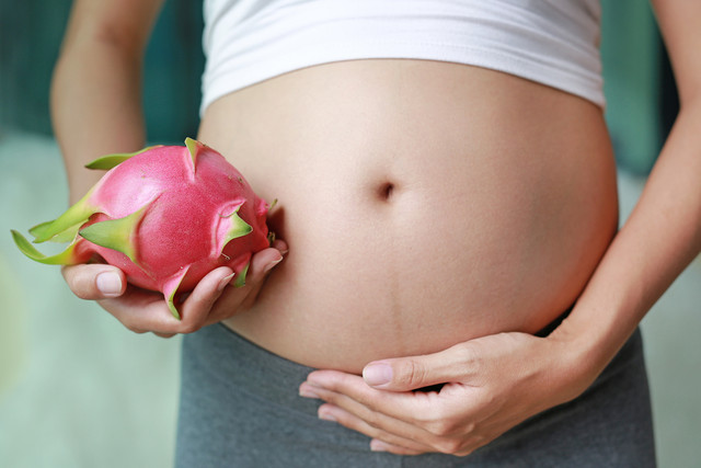  Ibu hamil makan buah naga. Foto: Shutter Stock