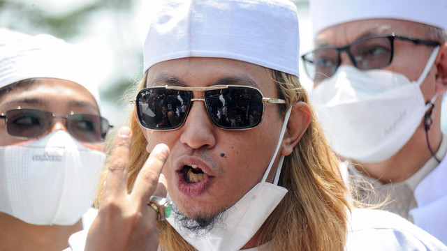 Penceramah Bahar Smith (tengah) memberikan keterangan kepada media saat tiba di Polda Jabar untuk menjalani pemeriksaan di Bandung, Jawa Barat, Senin (3/1/2022). Foto: Raisan Al Farisi/Antara Foto