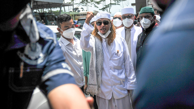 Penceramah Bahar Smith (tengah) memberikan keterangan kepada media saat tiba di Polda Jabar untuk menjalani pemeriksaan di Bandung, Jawa Barat, Senin (3/1/2022). Foto: Raisan Al Farisi/Antara Foto