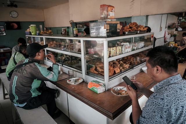 Warga menyantap makan pagi di salah satu warteg di Pasar Minggu, Jakarta Selatan. Foto: Jamal Ramadhan/kumparan