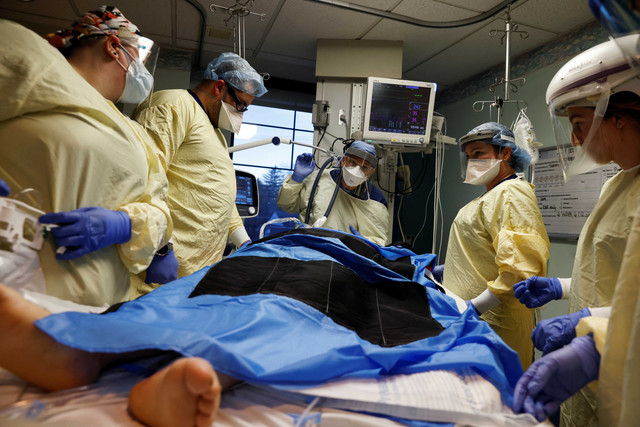 Staf medis merawat pasien penyakit virus corona (COVID-19) di ruang isolasi mereka di Unit Perawatan Intensif (ICU) di Rumah Sakit Western Reserve di Air Terjun Cuyahoga, Ohio, AS. Foto: REUTERS/Shannon Stapleton