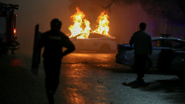 Sebuah mobil polisi yang terbakar selama protes terhadap kenaikan biaya LPG di Almaty, Kazakhstan Rabu (5/1/2022). Foto: Pavel Mikheyev/REUTERS