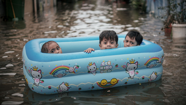 Contoh foto yang diambil pada cahaya terik: Tiga anak di perahu karet di kawasan banjir di Pademangan, Jakarta. Foto: Jamal Ramadhan/kumparan