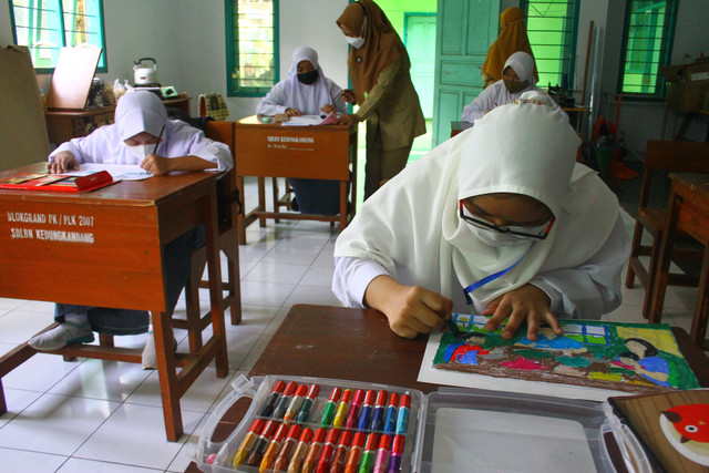 Siswa mengikuti pelajaran mewarnai saat pelaksanaan Pembelajaran Tatap Muka (PTM) 100 Persen hari pertama di SLB C Autis Jenjang SMA Kedungkandang, Malang, Jawa Timur. Foto: ANTARA FOTO/Ari Bowo Sucipto