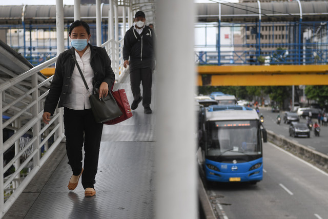 Sejumlah warga berjalan menuju halte bus Transjakarta. Foto: ANTARA FOTO/Akbar Nugroho Gumay