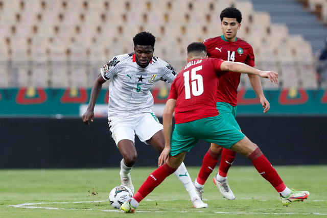 Pemain Maroko Selim Amallah dan Zakaria Aboukhlal mencoba menghadang pemain Ghana Thomas Partey pada pertandingan Grup C Piala Afrika di Stade Ahmadou Ahidjo, Yaounde, Kamerun. Foto: Mohamed Abd El Ghany/REUTERS