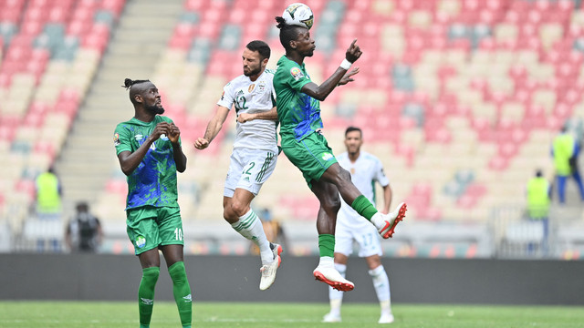 Pemain Aljazair Haris Belkebla duel dengan Sierra Leone John Kamara saat berebut bola saat pertandingan Grup E Piala Afrika 2021 di Stade de Japoma di Douala, Selasa (11/1/2022). Foto: Charly Triballeau/AFP