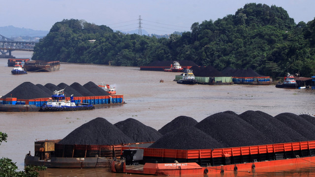 Tumpukan batu bara terlihat diangkut dengan tongkang di Samarinda, Kalimantan Timur, Selasa (11/1). Foto: AKSARA M. RAHMAN/AFP