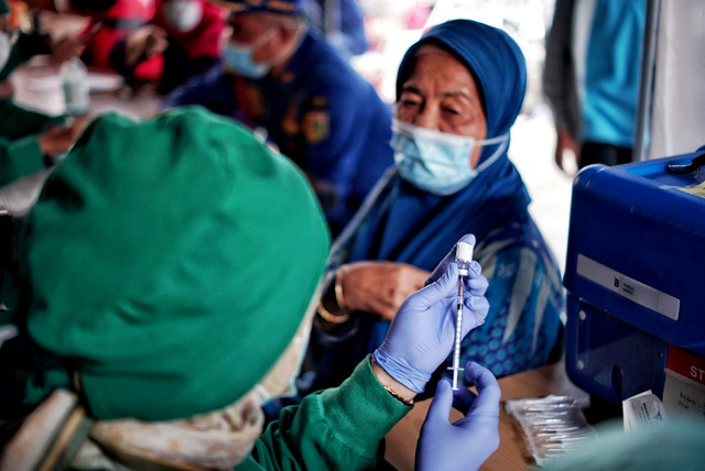 Tenaga kesehatan bersiap menyuntikkan vaksin COVID-19 dosis ketiga kepada warga saat vaksinasi booster COVID-19 di Puskesmas Kecamatan Kramat Jati, Jakarta Timur, Jakarta, Rabu (12/1/2022). Foto: Jamal Ramadhan/kumparan