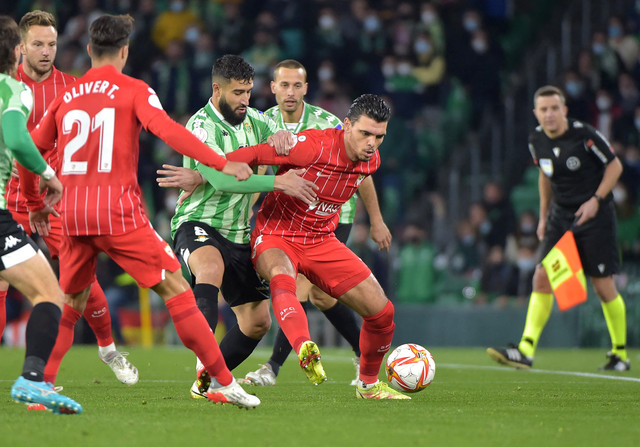 Pemain Real Betis Nabil Fekir berebut bola dengan pemain Sevilla Karim Rekik di Benito Villamarin stadion di Sevilla, Spanyol, Sabtu (15/1/2022). Foto: CRISTINA QUICLER/AFP